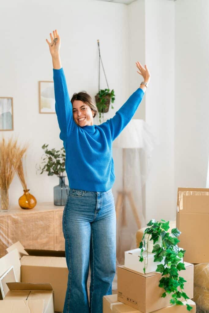 Happy woman with raised arms in new apartment